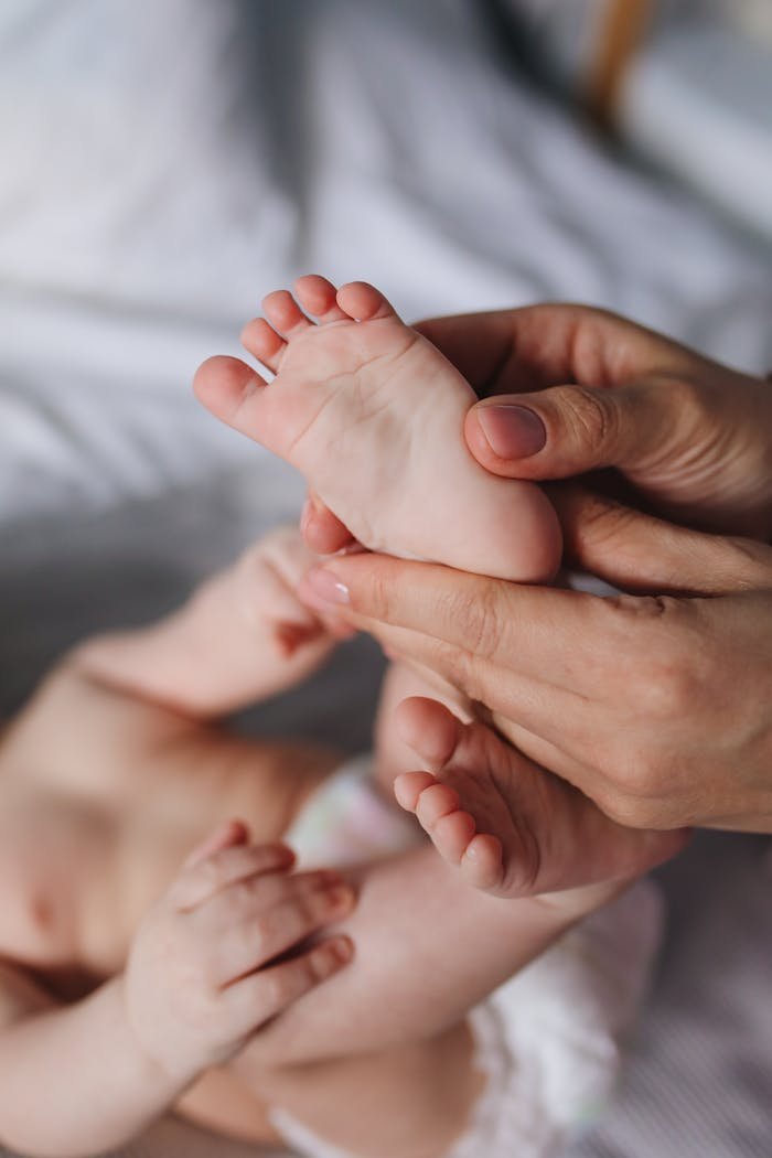 Crafting Captivating Headlines: Your awesome post title goes here A close-up of a parents hands gently massaging a babys feet, showcasing tenderness and care.